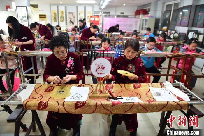 江西省級非遺豫章繡傳承人手把手指導小學生繡制2022年北京冬奧會吉祥物“冰墩墩”形象?！∮髟屏?攝