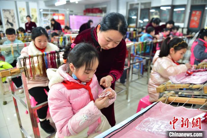 江西省級非遺豫章繡傳承人手把手指導小學生繡制2022年北京冬奧會吉祥物“冰墩墩”形象?！∮髟屏?攝