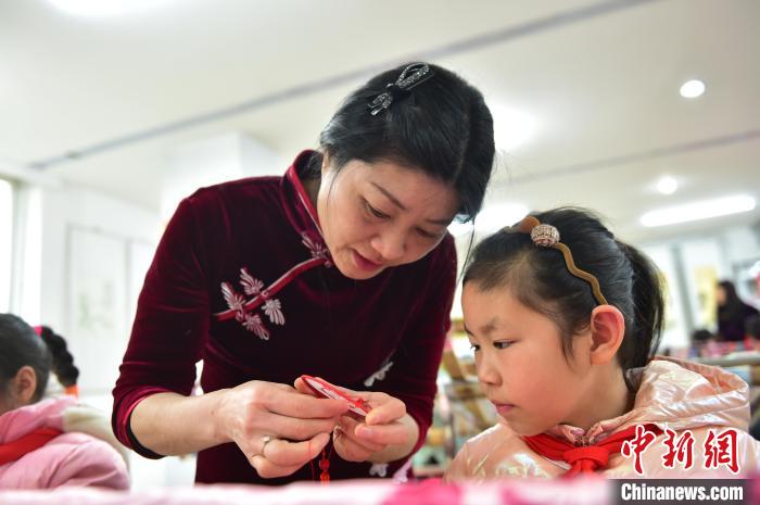 江西省級非遺豫章繡傳承人手把手指導小學生繡制2022年北京冬奧會吉祥物“冰墩墩”形象?！∮髟屏?攝