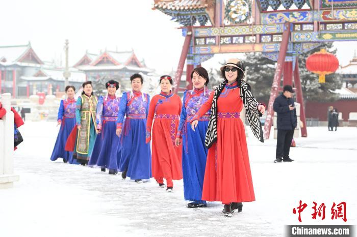 2月13日，老年人在呼和浩特市大召?gòu)V場(chǎng)拍照“打卡”。　劉文華 攝