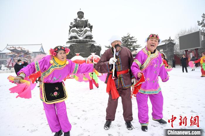 2月13日，秧歌隊(duì)在呼和浩特市大召?gòu)V場(chǎng)雪中起舞?！⑽娜A 攝