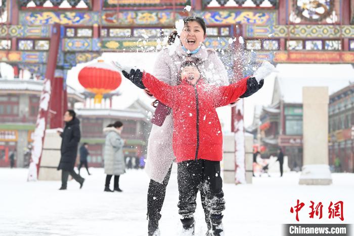 2月13日，家長(zhǎng)與小朋友在呼和浩特市大召?gòu)V場(chǎng)享雪趣。　劉文華 攝