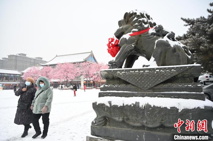 2月13日，民眾在呼和浩特市大召?gòu)V場(chǎng)雪中漫步?！⑽娜A 攝