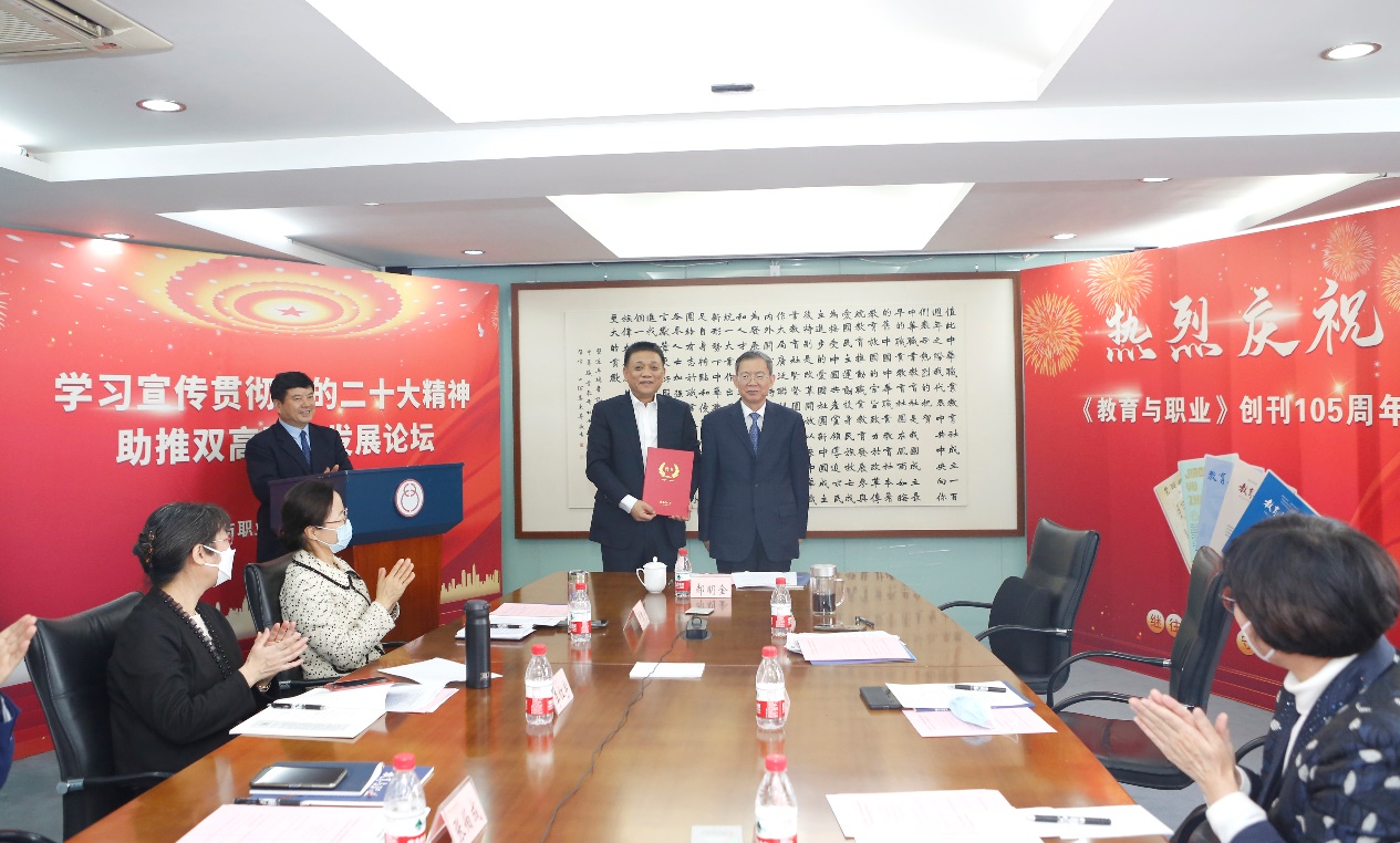 郝明金為《教育與職業(yè)》雜志編委代表陳曉明頒發(fā)聘書。中華職教社供圖