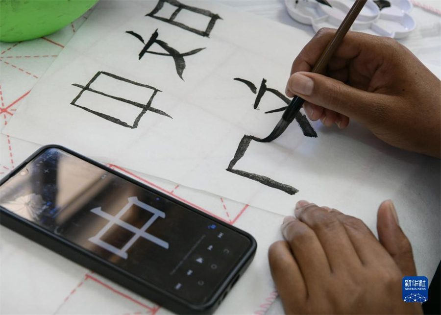 4月18日，肯尼亞學(xué)生在內(nèi)羅畢大學(xué)孔子學(xué)院舉辦的活動(dòng)上寫毛筆字?？夏醽唭?nèi)羅畢大學(xué)孔子學(xué)院18日舉辦“中文，增進(jìn)文明對(duì)話”主題活動(dòng)，慶祝即將到來(lái)的第14個(gè)聯(lián)合國(guó)中文日?？夏醽唽W(xué)生參與互動(dòng)，進(jìn)行書法、剪紙、唱中文歌等活動(dòng)。新華社記者 韓旭 攝