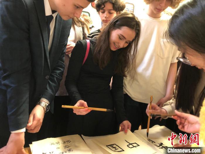 4月21日，莫斯科國立語言大學孔子學院附屬中學舉辦“國際中文日”活動，學生們學寫漢字?！∧箍茋⒄Z言大學孔子學院 供圖