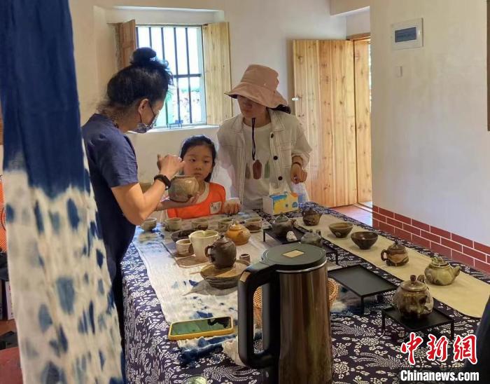 圖為：游客正在咨詢臺灣柴燒作品。　葉秋云 攝