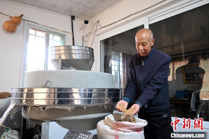 李家莊村民谷文朝重拾父輩的手藝，做起石磨面粉的營生?！〉杂鸺?攝