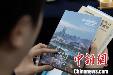 參展觀眾閱讀浙江文旅手冊?！《≌裾?攝