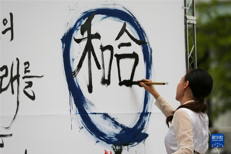 5月30日，在韓國首爾舉辦的“中日韓合作之日”慶?；顒又?，表演者進行中日韓精神——2023年度漢字“和合”書法表演。新華社記者 王益亮 攝