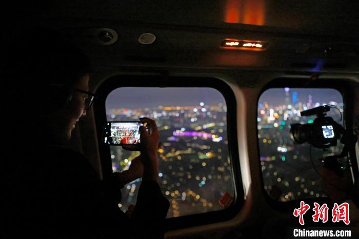 6月3日晚，游客乘坐上海新空直升機有限公司直升機開啟鳥瞰黃浦江空中圓夢之旅，并用手機拍攝城市夜景?！∫罅⑶?攝