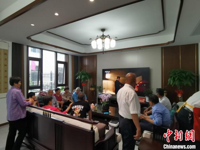 親友們集中在費(fèi)俊龍家中觀看返程的視頻?！＄娚?攝