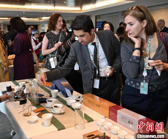現(xiàn)場(chǎng)觀眾觀看中國(guó)展臺(tái)茶藝表演、了解茶文化?！【笜?攝