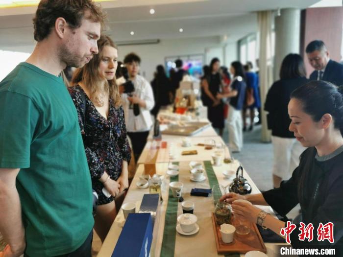 現(xiàn)場(chǎng)觀眾觀看中國(guó)展臺(tái)茶藝表演、了解茶文化?！【笜?攝