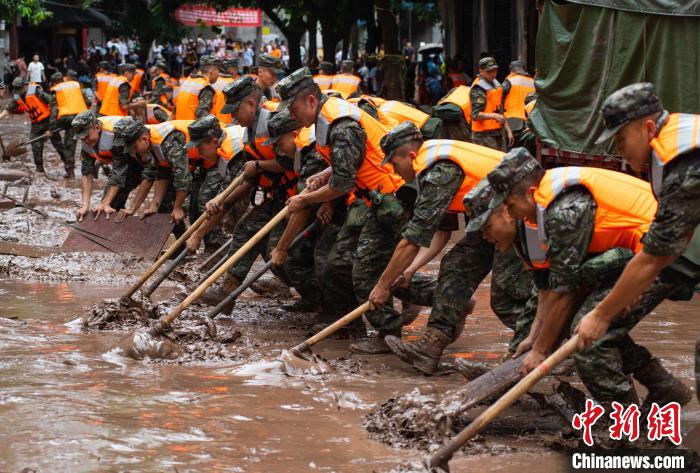 7月4日，萬(wàn)州區(qū)五橋街道，武警官兵清理街道上的淤泥?！∪矫宪?攝