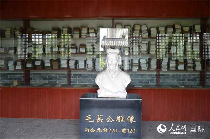 河間詩(shī)經(jīng)齋毛萇雕像。雕像后書櫥中陳列的是歷代各版本《詩(shī)經(jīng)》及譯本。 人民網(wǎng) 趙昭攝