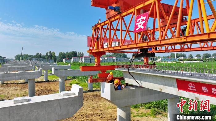 長25米重80噸的箱梁平穩(wěn)、精準地落在S314分離式立交橋25號和26號墩上?！⒂癫?攝