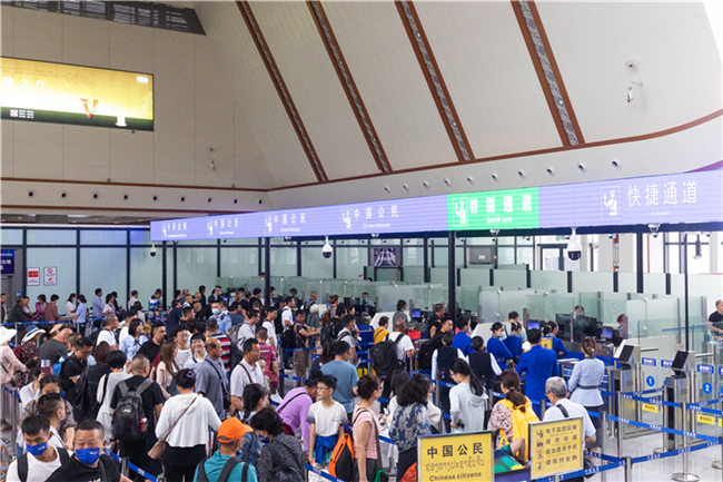 7月22日，乘坐中老鐵路國(guó)際旅客列車(chē)的旅客在磨憨邊檢大廳排隊(duì)候檢。衛(wèi)海林 攝