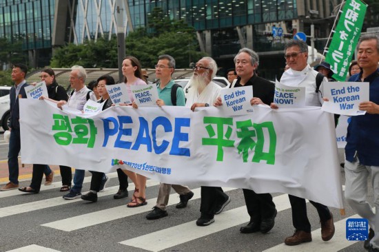 7月22日，在韓國首爾，人們手舉標(biāo)語參與反戰(zhàn)游行。新華社發(fā)（楊暢 攝）