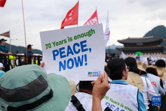 7月22日，在韓國首爾，人們手舉標(biāo)語參與反戰(zhàn)游行。新華社發(fā)（楊暢 攝）