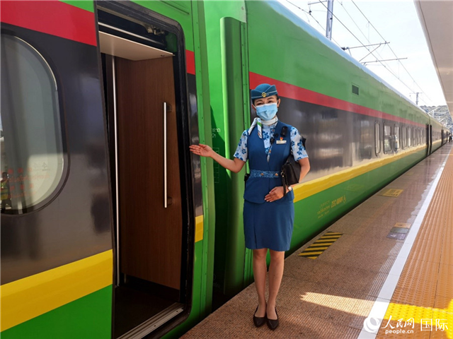 趙瑩靜站在“復(fù)興號”國際旅客列車車廂門口歡迎旅客上車。人民網(wǎng) 杜明明攝