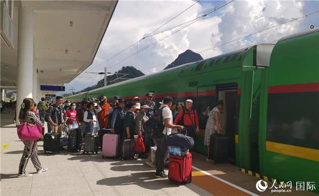 乘坐中老鐵路國際旅客列車的旅客在老撾瑯勃拉邦站排隊上車。人民網(wǎng)記者 杜明明攝
