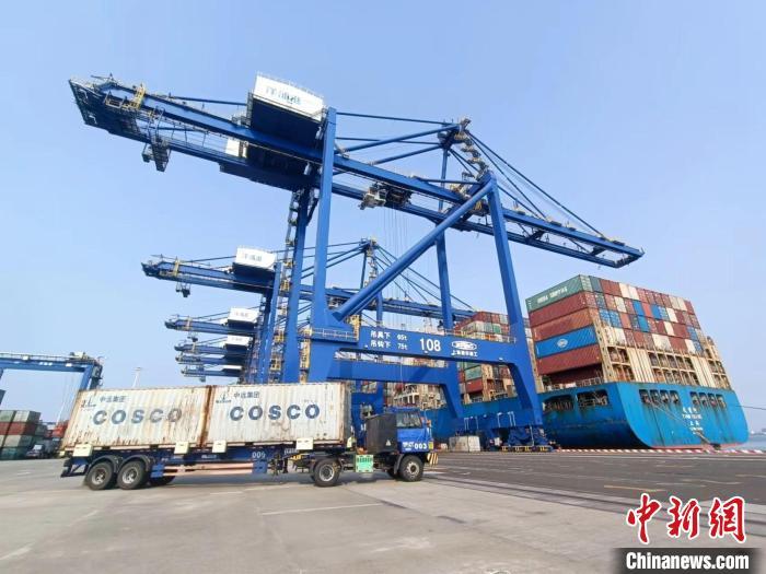 圖為海南洋浦國(guó)際集裝箱碼頭，卡車將集裝箱從后方堆場(chǎng)運(yùn)往碼頭裝卸區(qū)?！?jiān)潞?攝