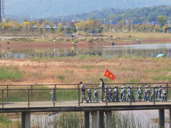 　　10月24日，秋游的幼兒園小朋友在老師帶領(lǐng)下走在清水塘公園里的木橋上。本報(bào)記者 常雯宜攝