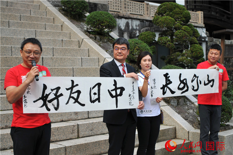 東京中國(guó)文化中心主任羅玉泉展示其為本次活動(dòng)書寫的題詞“中日友好，山高水長(zhǎng)”。人民網(wǎng) 蔣曉辰攝