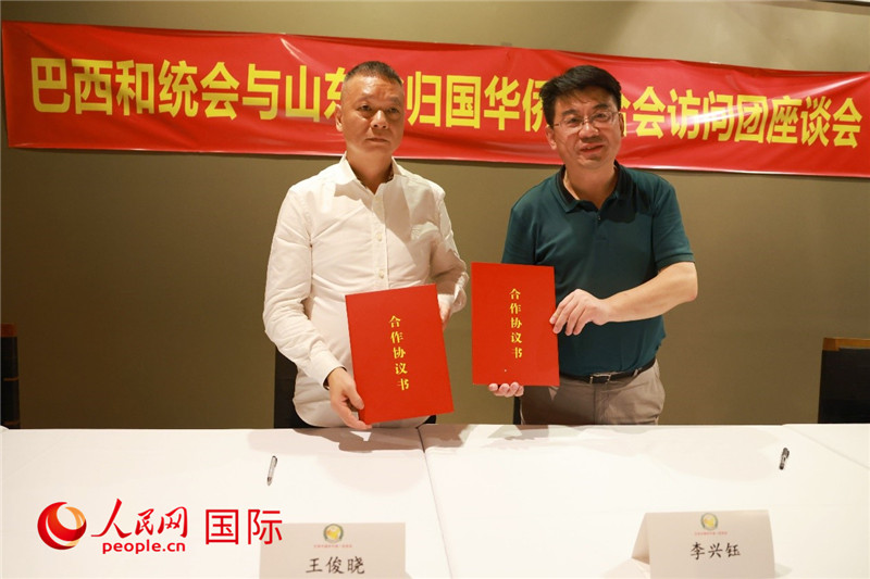 中國僑聯(lián)副主席、山東省僑聯(lián)主席李興鈺（右）與巴西和統(tǒng)會會長王俊曉簽署合作協(xié)議書。人民網(wǎng)記者 陳海琪攝