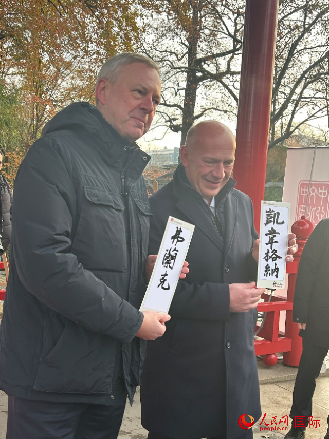 柏林市長韋格納（右）、動(dòng)物園監(jiān)事會主席布魯克曼（左）手持中國文化中心工作人員現(xiàn)場手書的中文名字。人民網(wǎng)記者 徐馨攝