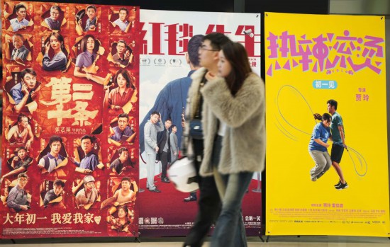 這是2月17日，在沈陽一家影院，觀眾從海報(bào)前經(jīng)過。新華社記者李鋼攝