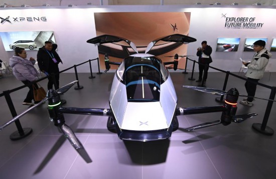 2023年12月1日，在鏈博會智能汽車鏈展區(qū)小鵬汽車展臺，參觀者觀看一臺智能飛行器。新華社記者蔡湘鑫攝