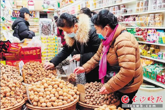 　　在長沙南門口菜市場附近的一家炒貨店內(nèi)，市民正在選購年貨。　　長沙晚報(bào)全媒體記者 范宏歡 攝