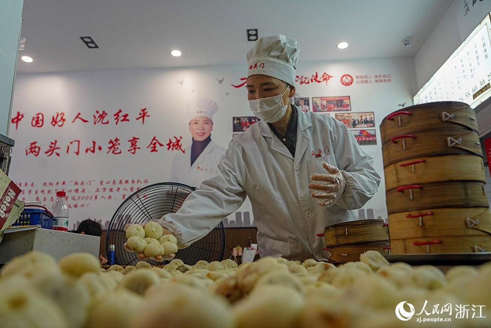 3月31日，在浙江省嵊州市甘霖鎮(zhèn)，嵊州小吃從業(yè)者沈紅平把蒸熟的小籠包晾涼，打包冷藏售賣。人民網(wǎng) 章勇濤攝