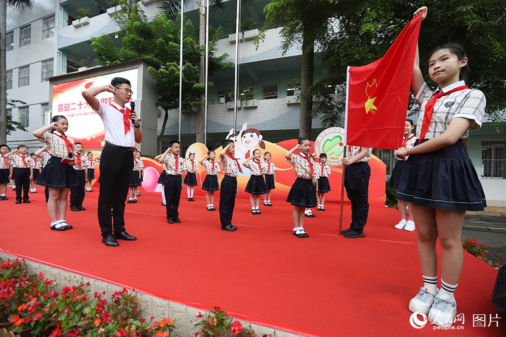 5月31日，在廣西壯族自治區(qū)南寧市民主路小學(xué)，學(xué)校大隊輔導(dǎo)員帶領(lǐng)少先隊員呼號。人民網(wǎng)記者 嚴(yán)立政攝