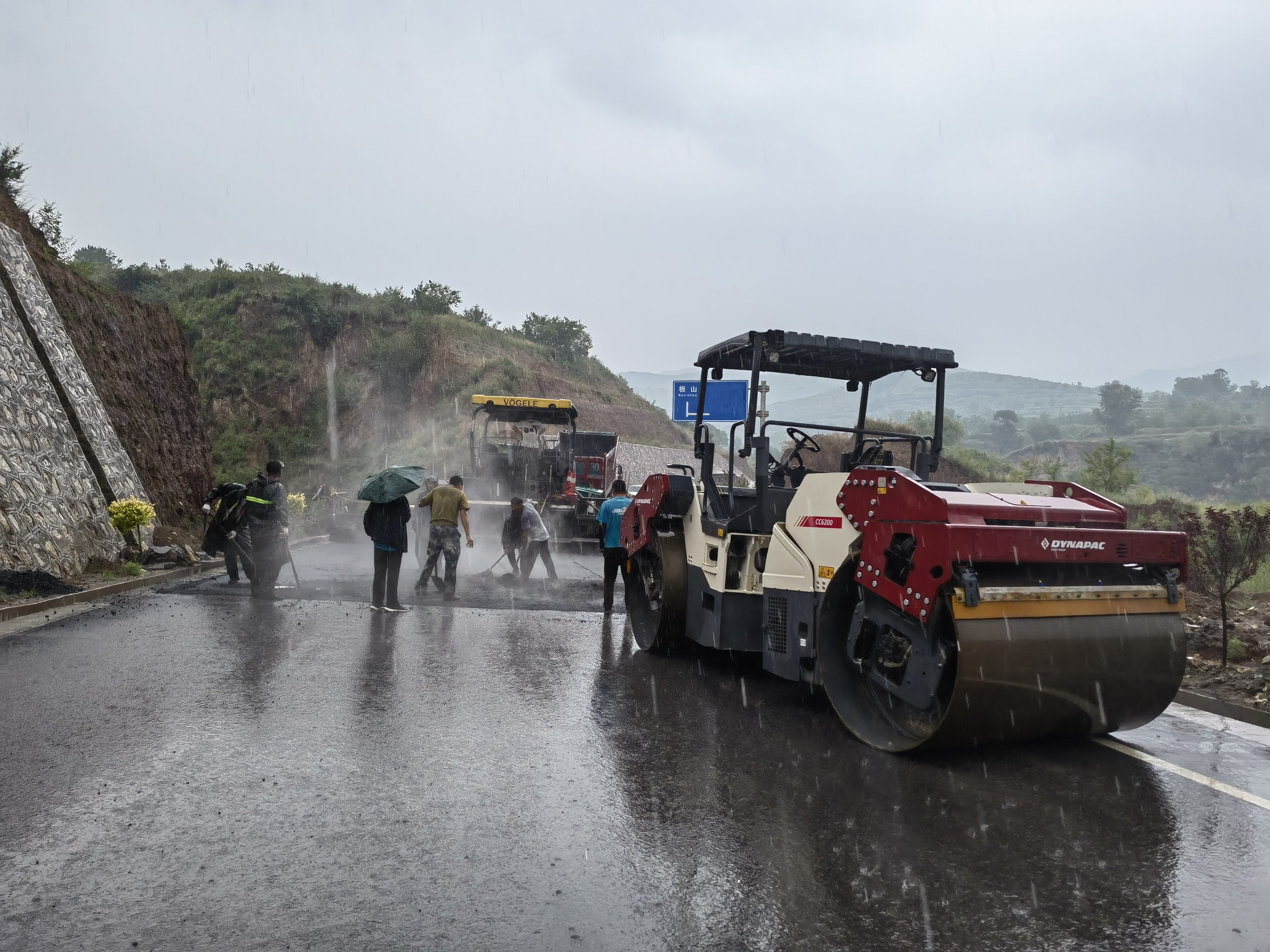 路橋工人在大雨中搶修道路。李華英 攝
