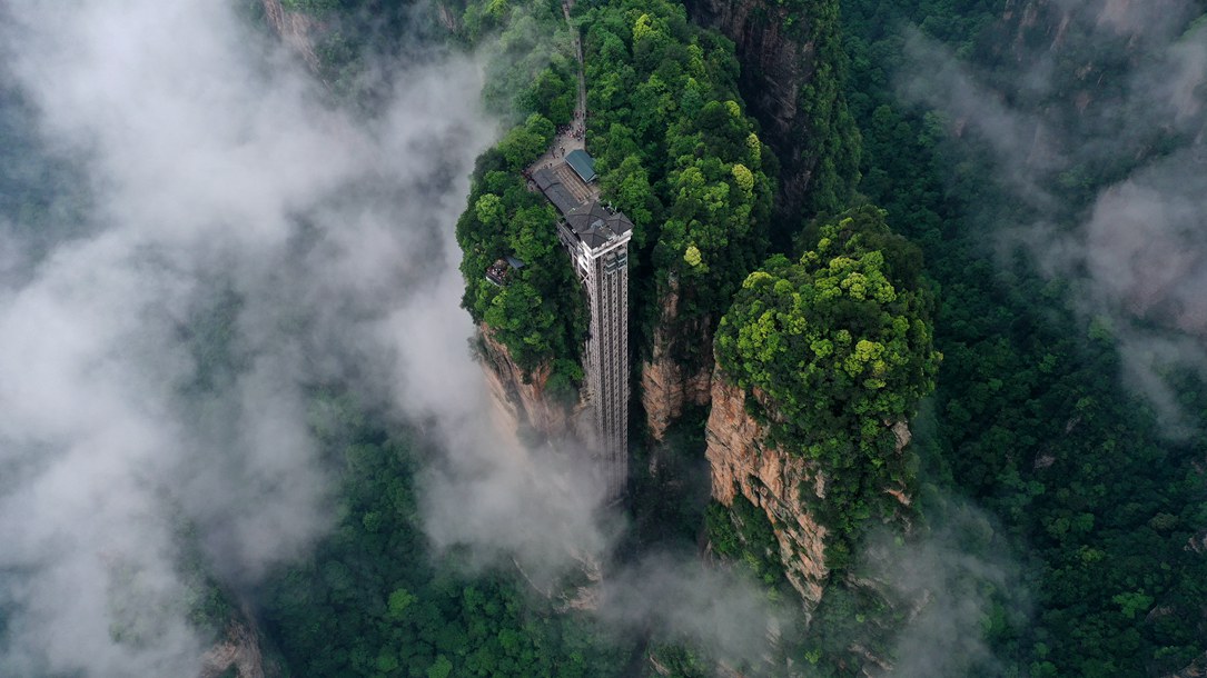 位于張家界武陵源景區(qū)的百龍?zhí)焯蓁偳对谠旗F繚繞的峰林間，雄偉壯觀。吳勇兵攝