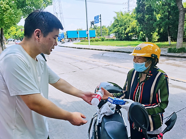 何超為過路的老人送上礦泉水和冷飲。人民網(wǎng)記者 王繼亮攝