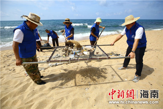 環(huán)保志愿者用篩網(wǎng)“淘”出海灘上的垃圾。