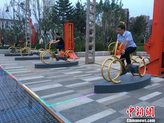 市民使用公園內(nèi)的健身設施?！「呒t超 攝