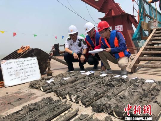 圖為勘察設(shè)計人員與海事局工作人員查看巖芯情況?！∥赫?攝