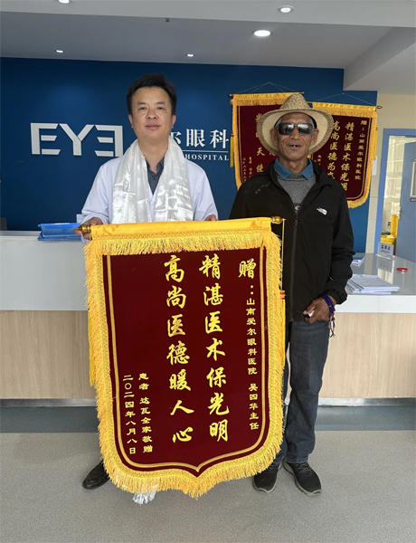 達(dá)瓦老人向吳四華（左）贈送錦旗。受訪者供圖