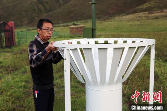 圖為班瑪縣氣象局工作人員在維護(hù)藏雪茶基地氣候站。青海省氣象局供圖