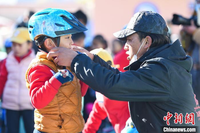 圖為拉薩市實驗幼兒園孩子在教練的幫助下穿戴頭盔。　何蓬磊 攝