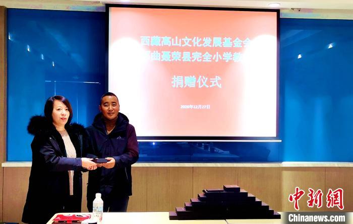 圖為西藏高山文化發(fā)展基金會理事長溫麗向聶榮縣完全小學負責人捐助儀器?！∮谫e 攝