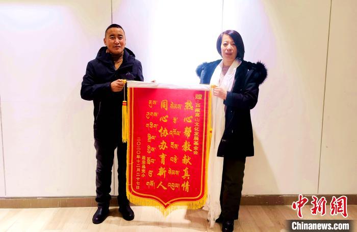 圖為聶榮縣完全小學向西藏高山文化發(fā)展基金會贈送錦旗?！∮谫e 攝