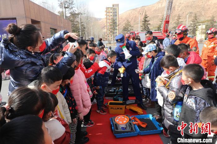 圖為小朋友們聽(tīng)消防員講解消防器材?！铨埥?攝