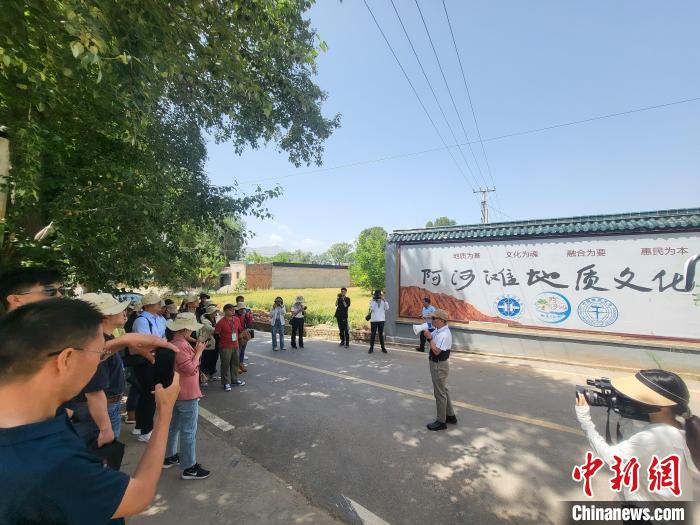 圖為中國地質(zhì)大學(xué)(北京)教授張緒教介紹村落情況?！『衍?攝