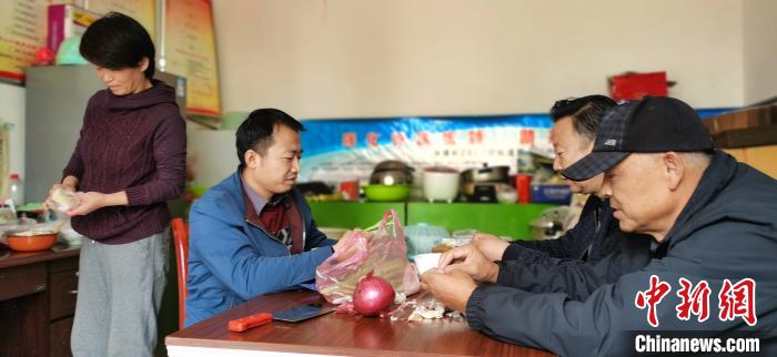 圖為扶貧路上“臨時(shí)一家人”準(zhǔn)備午餐?！∥航ㄜ?攝